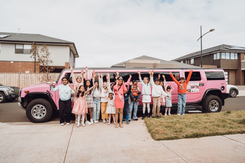 Girls by pink hummer limousine