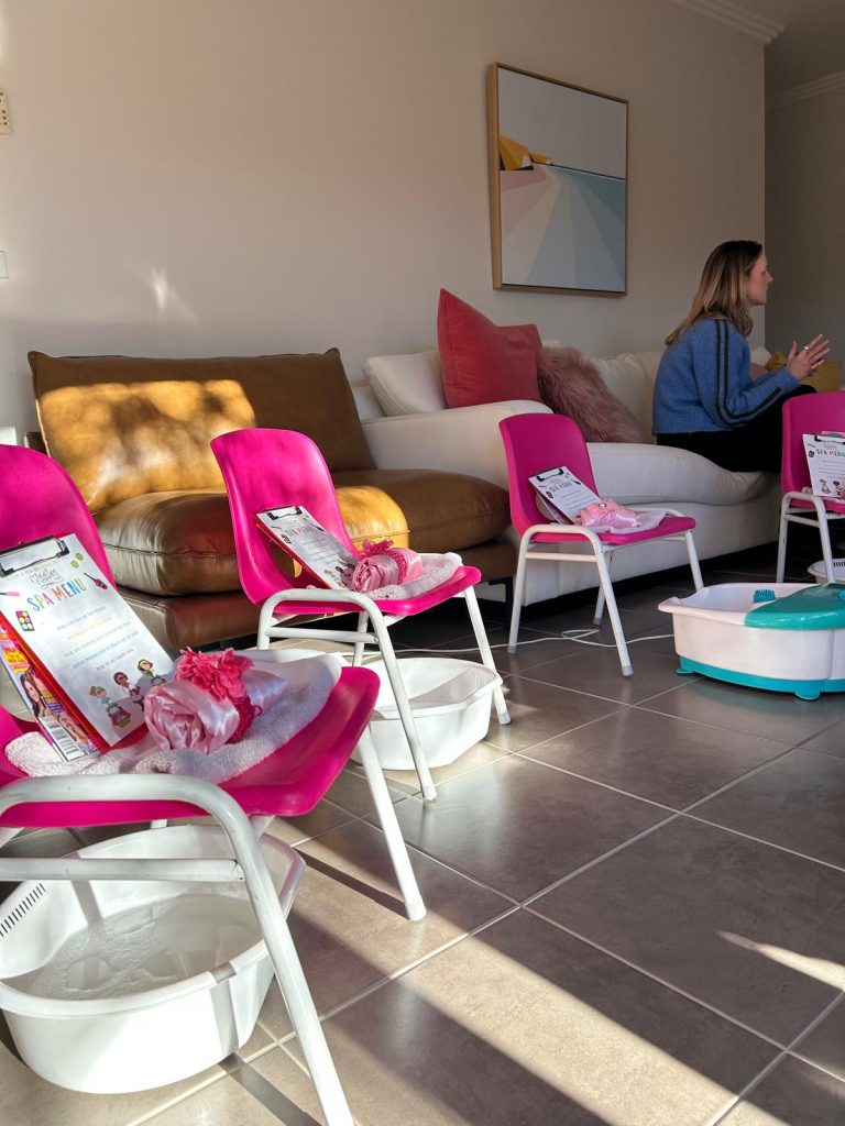 spa party set up with pink chairs, clipboards, robes, spa items