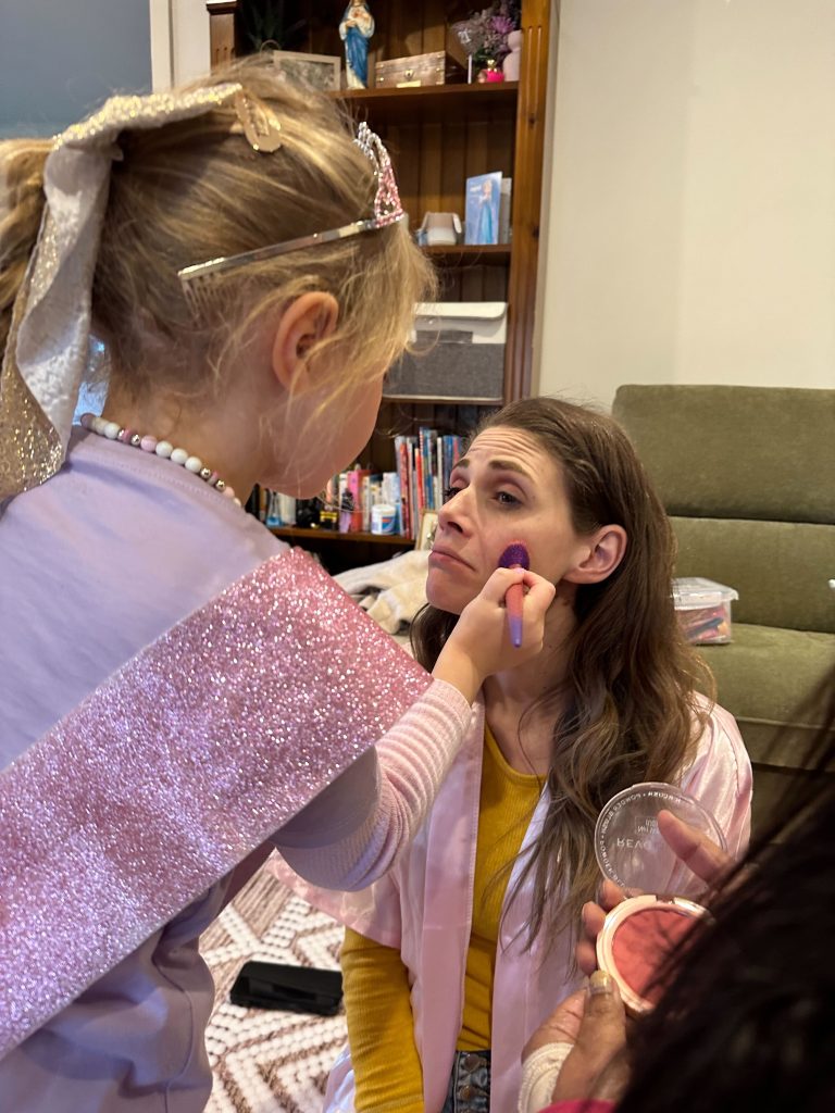 daughter puts makeup on mum